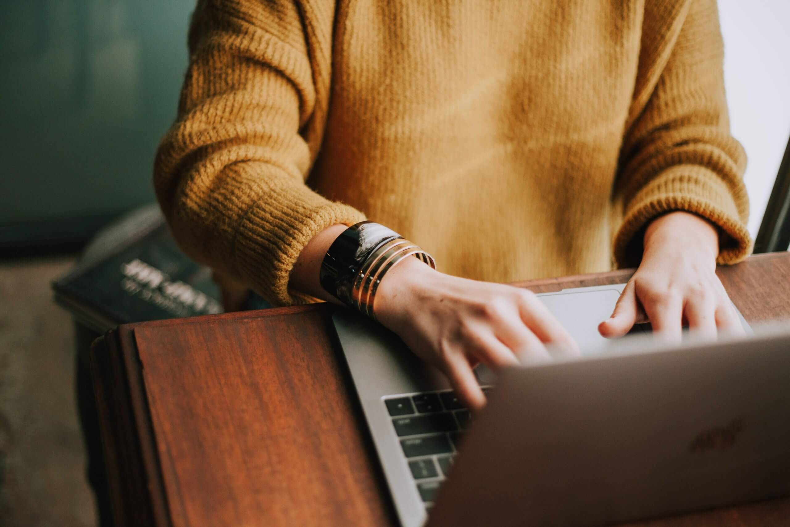 Une femme tape sur le clavier de son ordinateur.